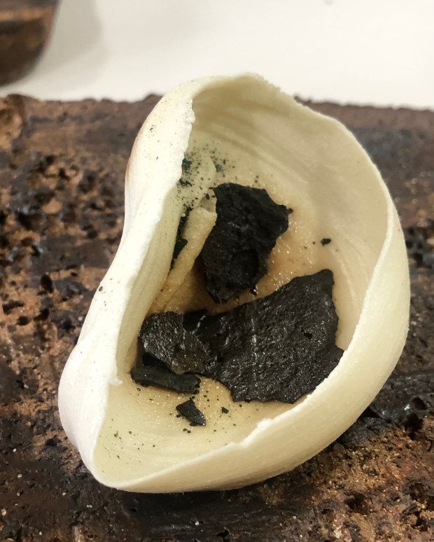 A porcelain piece on a rusted looking plinth like slab